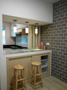 a kitchen with two wooden stools at a counter at 758 Residence in Miri