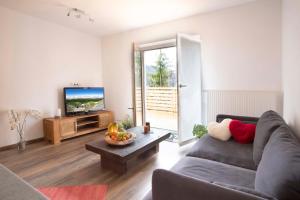 sala de estar con sofá y TV en Ferienwohnungen Karwendelbahn en Mittenwald