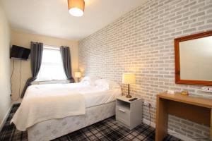 a hotel room with a bed and a mirror at Acorn Guest House in Penrith