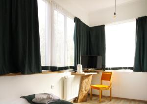a bedroom with green curtains and a desk and a chair at Insomnia in Akhaltsikhe