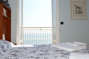 a bedroom with a bed with a view of the ocean at Appartamento "Abbracciando il Mare" in Laigueglia