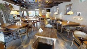 a restaurant with wooden tables and chairs in a room at Hotel City Bell in La Plata