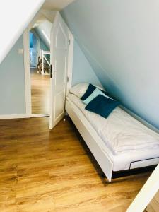 łóżko w pokoju z niebieską ścianą w obiekcie Apartamenty Platinum w Łukęcinie