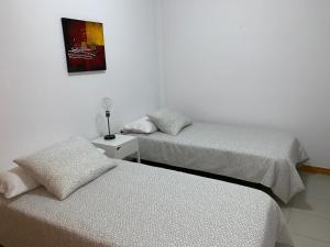 Una habitación con dos camas y un cuadro en la pared. en apartamento Augusto, en Los Llanos de Aridane