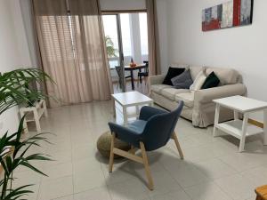 una sala de estar con un sofá y una silla en apartamento Augusto, en Los Llanos de Aridane