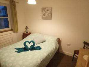 a bedroom with a bed with two blue stuffed animals on it at Sammy's place in Hayle