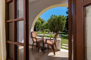 a door leading to a patio with a table and two chairs at Gaia Garden in Kos