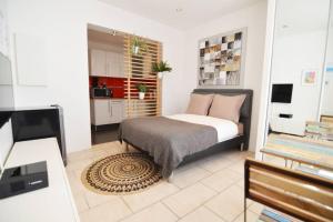 een kleine slaapkamer met een bed en een keuken bij Gascogne, Studio confortable- centre-ville- 5 min de la plage - Wifi in Biarritz