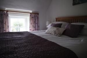 เตียงในห้องที่ Cornish Thatched Cottage