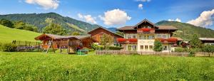 a large house in the middle of a green field at Appartment Ransburggut in Flachau