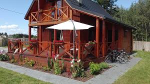 a small wooden building with an umbrella and bicycles at Dziki zakątek Piskornia dom z sauną in Piskornia