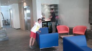 un joven parado frente a una silla azul en Hotel 9 Sant Antoni, en Ribes de Freser