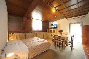 a bedroom with a bed and a table with chairs at Residence Regina Delle Dolomiti in Rocca Pietore