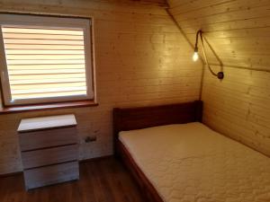 a small bedroom with a bed and a window at Domki letniskowe KAMA Polańczyk 514-280-102 in Solina