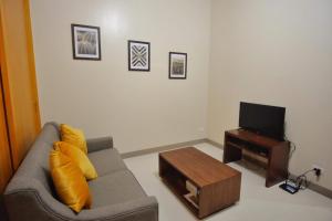 uma sala de estar com um sofá e uma televisão em One Uptown Residences in Uptown BGC em Manila