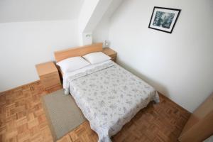 1 dormitorio pequeño con 1 cama y una foto en la pared en House Milan en Rastovača