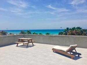 a patio with two picnic tables and the ocean at Surfzone Beachside Apartments in Santa Maria