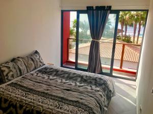 Un dormitorio con una cama y una ventana grande. en Surfzone Beachside Apartments, en Santa Maria