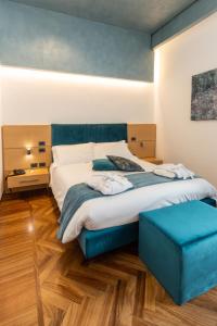 una camera da letto con un grande letto e uno sgabello blu di Palazzo Filisio - Regia Restaurant a Trani