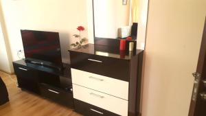 a black and white dresser with a television and a dresser at Family Hotel Solar Central in Sunny Beach