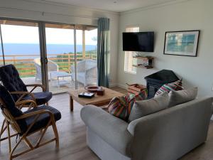 a living room with a couch and a fire place at Trinity Farm Ocean view Cottage in Plettenberg Bay