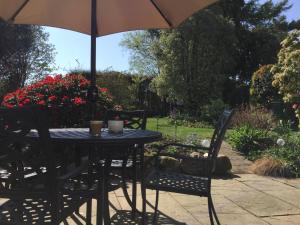 a table and chairs with an umbrella on a patio at Maggi’s Home from Home in Sheffield