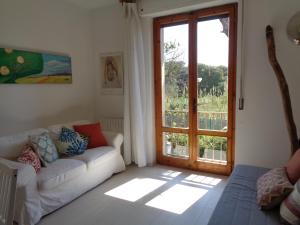 uma sala de estar com um sofá e uma porta de vidro deslizante em La casa di Nina em Quercianella