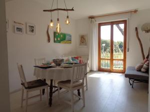 una sala da pranzo con tavolo, sedie e una finestra di La casa di Nina a Quercianella