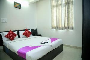 班加罗尔Orange Corner, Near Kempegowda Airport, Airport Pickup And Drop Available 24x7的卧室里有一张大床，配有红白相间的枕头
