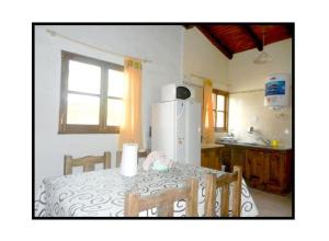 une cuisine avec une table et un réfrigérateur blanc dans l'établissement Cabañas Haras de Cuyo, à San Rafael