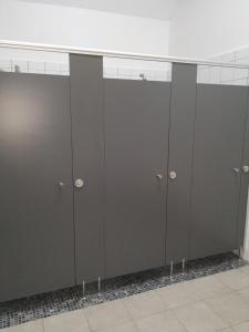 a row of gray lockers in a room at O Albergue de Selmo in Arzúa