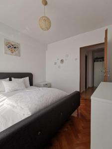 a bedroom with a bed with white sheets and a doorway at Central View Apartment in Timişoara