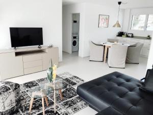 a living room with a couch and a tv at Easy-Living Apartments Dietwil in Dietwil