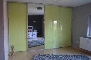 Habitación con puertas correderas verdes y espejo. en Landidyll, en Uelzen