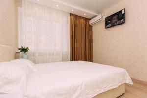 Un dormitorio con una cama blanca y una ventana. en Люкс апартамента на Харьковской возле ТЦ Лавина, en Sumy