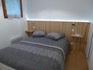 a bed with two pillows in a small room at Confortable appartement T2 cabine Loudenvielle in Loudenvielle