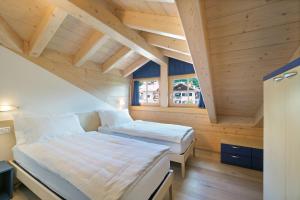 1 dormitorio con 2 camas en una cabaña de madera en Appartamenti Casa Salesai, en Carano