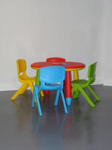 una mesa con sillas de diferentes colores alrededor en Duplex Frain, en Lesaka