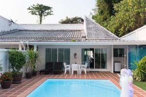 a house with a swimming pool in the yard at Baan Promphun Pool Villa by BV in Ban Pa Khlok