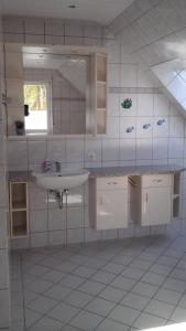 a white bathroom with a sink and a mirror at Pension Stahlberg in Lübz +9 photos