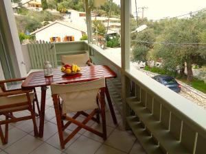 a table on a balcony with a bowl of fruit on it at Green View Apartments in Agios Nikitas