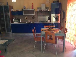 a kitchen with blue cabinets and a table and chairs at la casa di laura in Calascibetta