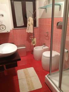 La salle de bains est pourvue de toilettes blanches et d'un lavabo. dans l'établissement la casa di laura, à Calascibetta