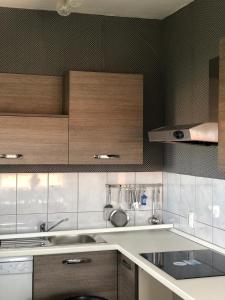 una cocina con armarios de madera y fregadero en Apartments Tepavac, en Novi Vinodolski