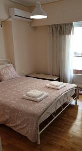 a bedroom with a bed with two towels on it at Koukaki apartment near Acropolis in Athens