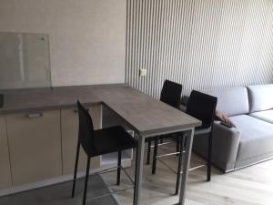 een tafel en stoelen in een woonkamer met een bank bij Apartament West Side in Kiev