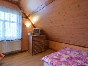 a bedroom with a bed and a tv on a dresser at Gajówka Sajczyce - gospodarstwo agroturystyczne in Chełm