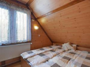 a bedroom with a bed in a wooden cabin at Gajówka Sajczyce - gospodarstwo agroturystyczne in Chełm