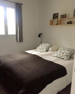 ein Schlafzimmer mit einem Bett mit zwei Kissen und einem Fenster in der Unterkunft Au Coin des Cerisiers in Montclus + 25 Fotos