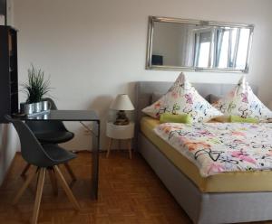Schlafzimmer mit einem Bett, einem Schreibtisch und einem Spiegel in der Unterkunft Ferienwohnung Seaview in Meersburg